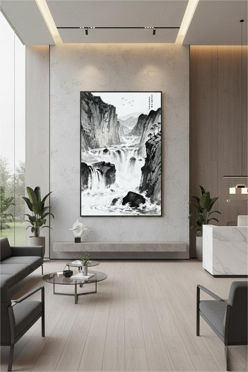 The River Carves Through Stone ink painting in a black frame above a stone ledge with lounge seating in a corporate lobby