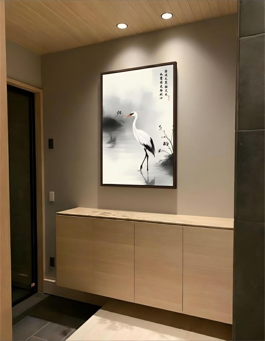 The Lone Egret upon Clear Waters ink painting in a black frame above a light wood cabinet in an entrance foyer.